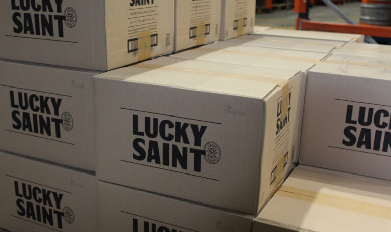 Boxes of Lucky Saint alcohol free beer stacked on top of each other
